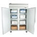 A Beverage-Air reach-in freezer with open glass doors and shelves full of boxes.