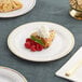 A Visions white plastic plate with a dessert and a cup of coffee.