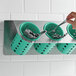 A green Steril-Sil container holding spoons.