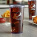 Two blue Pepsi plastic tumblers filled with soda and ice on a table in a fast food restaurant.