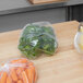 A plastic bag of carrots on a table.