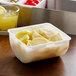 A white Thunder Group condiment dispenser insert with lemon slices in it.
