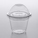 A clear plastic Choice plastic squat cup with a dome lid on a table.