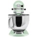 A KitchenAid Artisan Series mixer with a green top over a bowl.