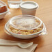 A plastic container with a lid on a table with food inside.