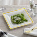 A Visions ivory square plastic plate with a salad on it on a table.
