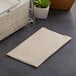 A stack of Hoffmaster Linen-Like Natural Kraft paper guest towels on a table next to a plant.