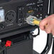 A hand plugging a yellow power cord into a black DuroMax XP4850EH generator.