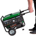 A man pushing a DuroMax portable generator.