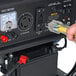 A hand plugging a power cord into a DuroMax XP5500E generator.