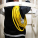 A man holding a yellow DuroMax triple tap extension power cord.