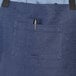 A blue Uncommon Chef denim apron with black webbing and a pocket.