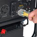 A person plugging a yellow power cord into a DuroMax XP5500EH generator outlet.