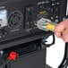 A hand plugging a yellow power cord into a DuroStar dual fuel generator.