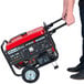 A person holding a red and black DuroStar portable generator.