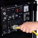 A person plugging a yellow DuroMax power cord into a generator.
