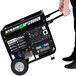 A man pushing a DuroMax portable dual fuel generator on wheels.