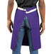 A man wearing a purple Uncommon Chef waist apron with natural webbing.