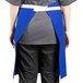 A person wearing a blue Uncommon Chef waist apron with natural webbing.