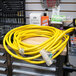 A yellow DuroMax extension cord with a triple tap on a table full of tools.
