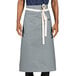 A person wearing a grey Uncommon Chef bistro apron with natural webbing.