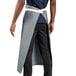 A man wearing a long gray Uncommon Chef Marvel Bistro apron.