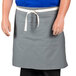 A man wearing a gray Uncommon Chef waist apron with white webbing.