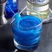 A blue cocktail with Spirdust Blue Indigo shimmer on a table.