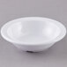 A white Carlisle Kingline melamine fruit bowl with a rim on a gray surface.