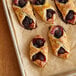 A tray of croissants with Boysenberries inside.