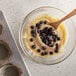 A bowl of 30 lb. IQF organic blueberries with a wooden spoon.