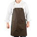 A man wearing a dark brown Uncommon Chef apron with natural webbing.