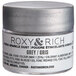 A silver Roxy & Rich container of grey powder with black text.
