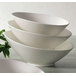 A stack of CAC bone white porcelain salad bowls.