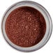A jar of brown sparkle dust with a white label.