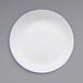 A white Crow Canyon Home enamelware plate with a blue rim.