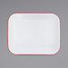 A white rectangular enamelware roasting pan with red trim.