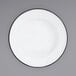 A close-up of a Crow Canyon Home white enamelware plate with a black rim.
