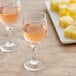 Two Acopa wine tasting glasses sit on a table next to a plate of cheese.