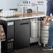 a close-up of a man pouring beer into a keg