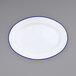 A white Crow Canyon Home enamelware plate with a blue rim.