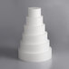 A stack of white cylindrical cake dummies.