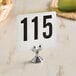 An American Metalcraft stainless steel low profile card holder with a white sign and black numbers.