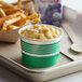 A tray with a Choice green paper cup filled with macaroni and cheese and fries.