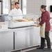 An Avantco countertop refrigerated prep rail on a counter with food.