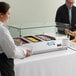 An Avantco countertop refrigerated prep rail with sneeze guard on a hotel buffet table.