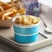 A tray with a Choice blue paper cup of macaroni and cheese and fries on a table.