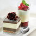 A dessert with chocolate and raspberry filling in a Solia clear plastic cube.