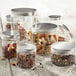 A collection of Solia clear plastic jars with aluminum lids filled with different types of food.