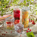 A group of Solia clear plastic jars filled with fruit and berries.